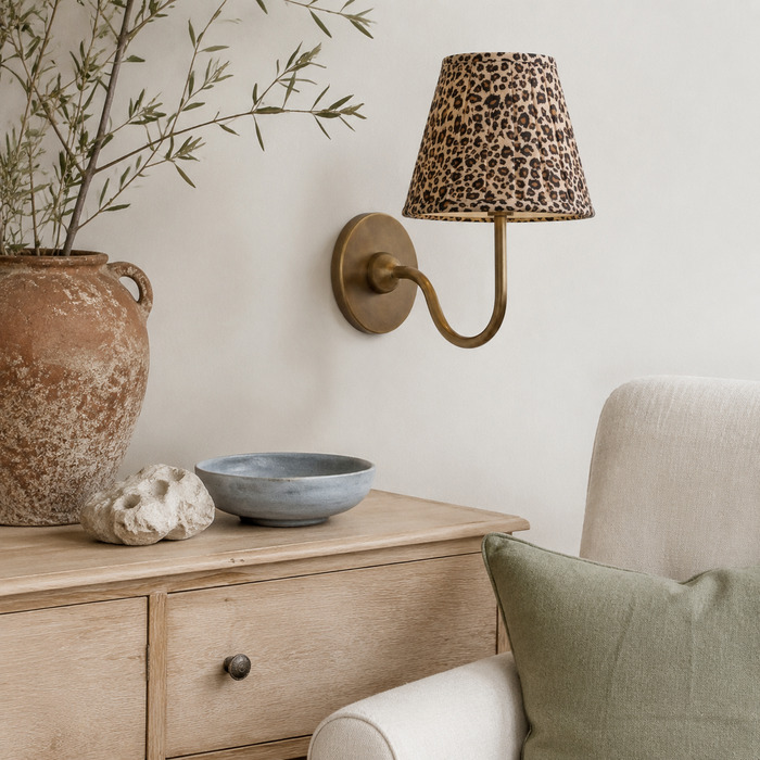 De Baylor wandlamp met luipaardprint vormt een smaakvol accent in een natuurlijke leeshoek.