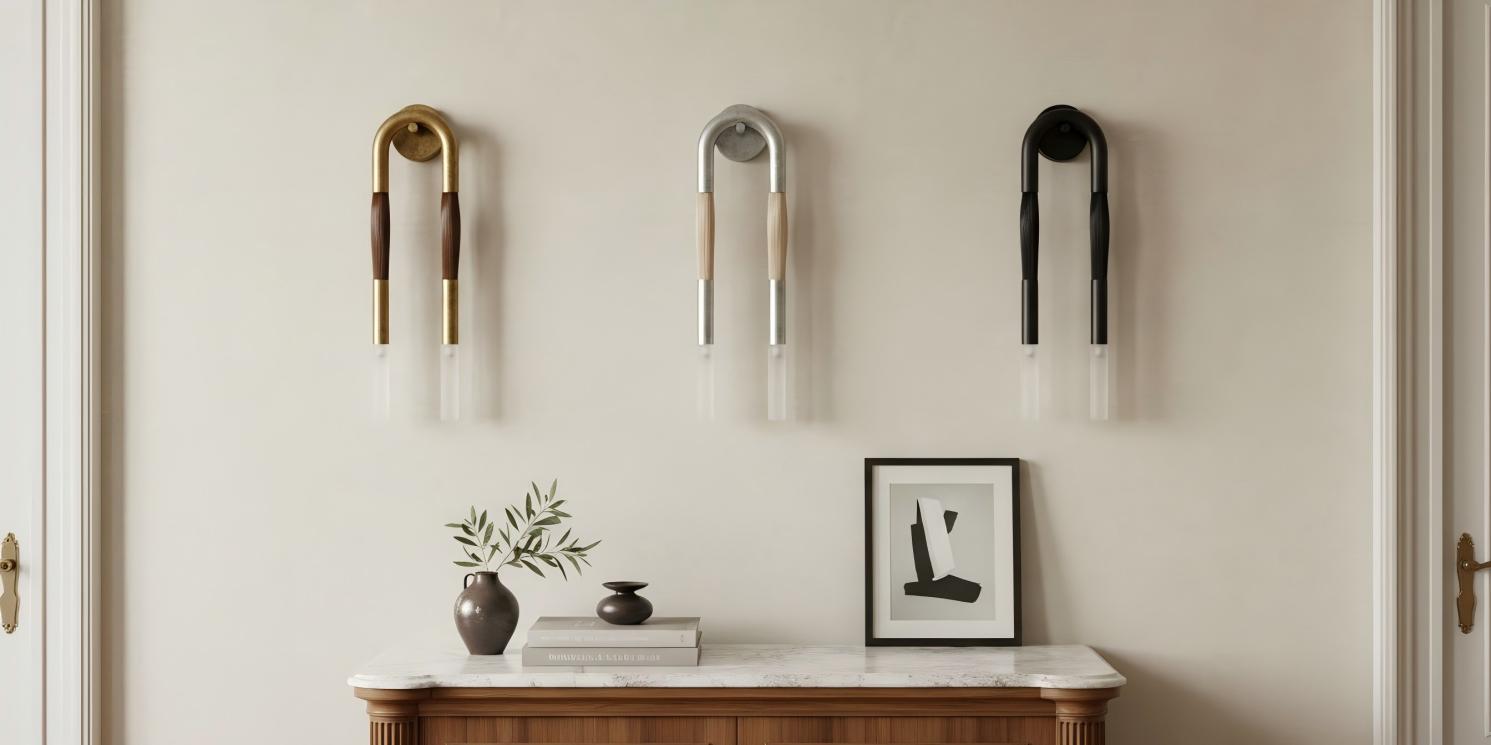 Strandia dubbele wandlamp in drie afwerkingen boven een console