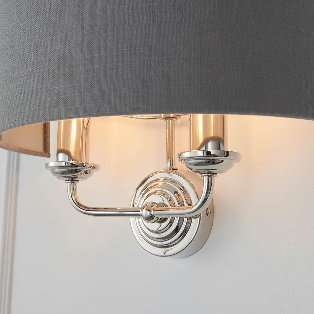 Detail van chromen Tela wandlamp met donkere kap