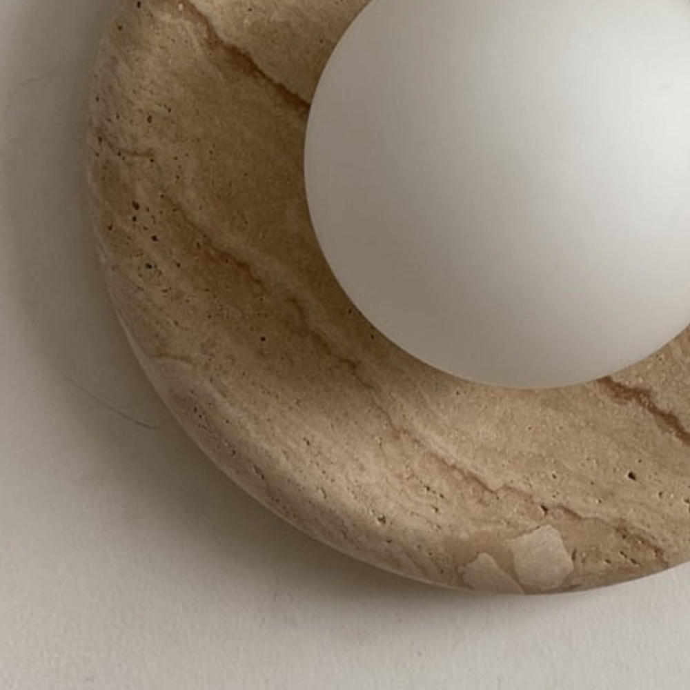 Detail van travertijn en glazen bol van de Oria wandlamp