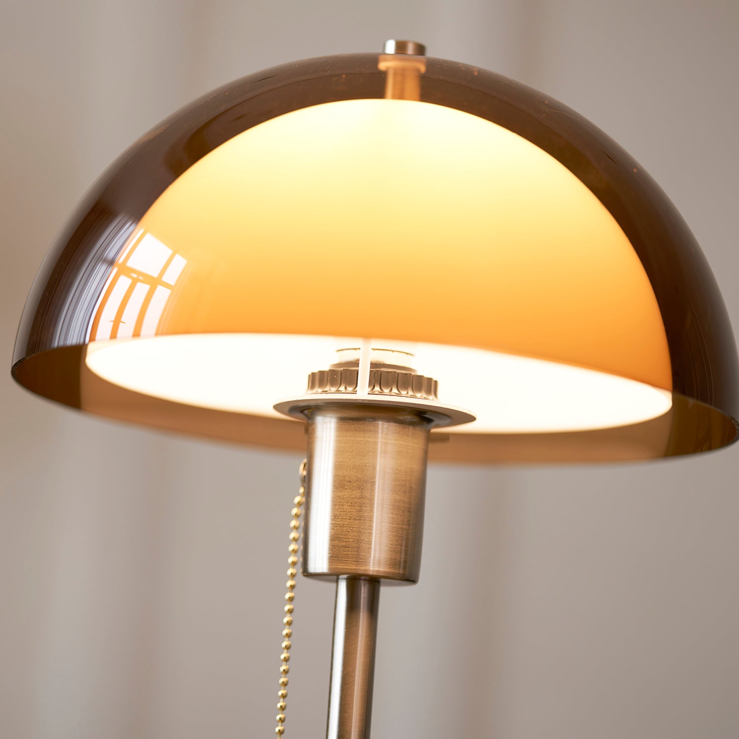 Detail van de ronde amberkleurige lampenkap