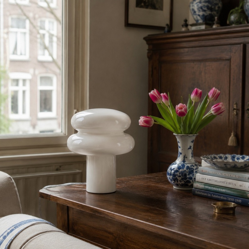 Witte opaalglazen tafellamp op een dressoir