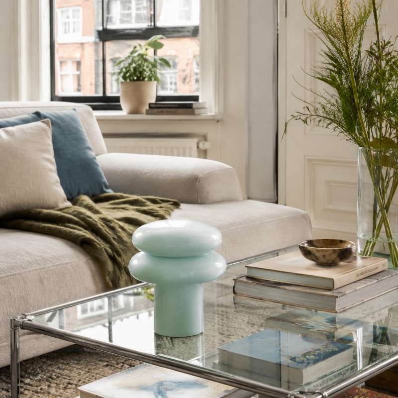 Lichtblauwe lamp op glazen salontafel