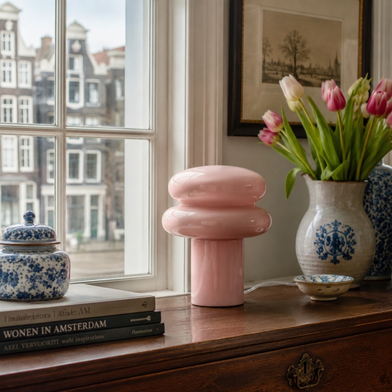 Roze opaalglazen tafellamp bij het raam