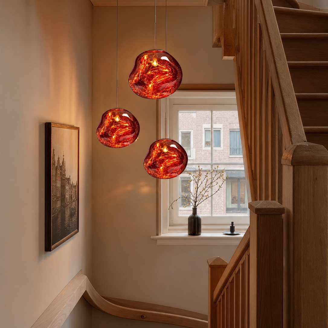 Drie rode lavavormige hanglampen bij een houten trap